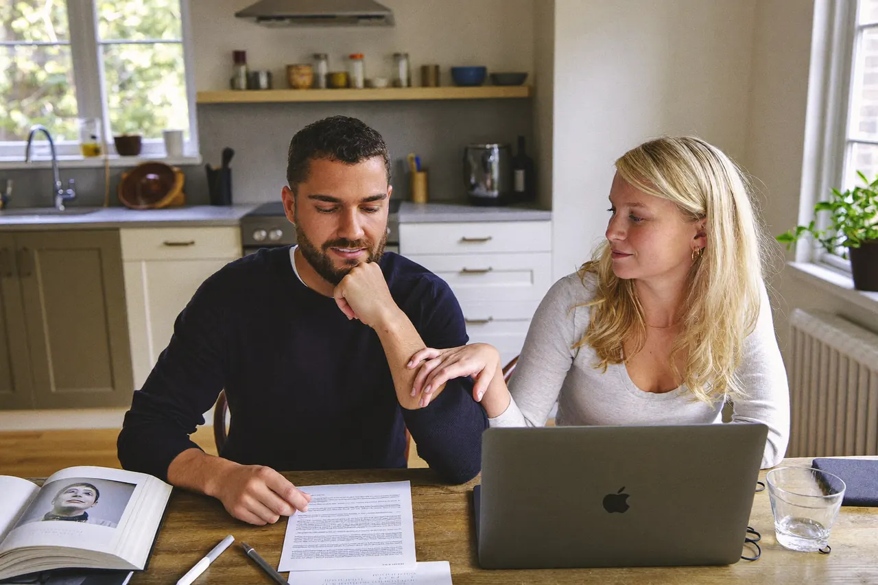 Homeowners comparing window quotes at a kitchen table