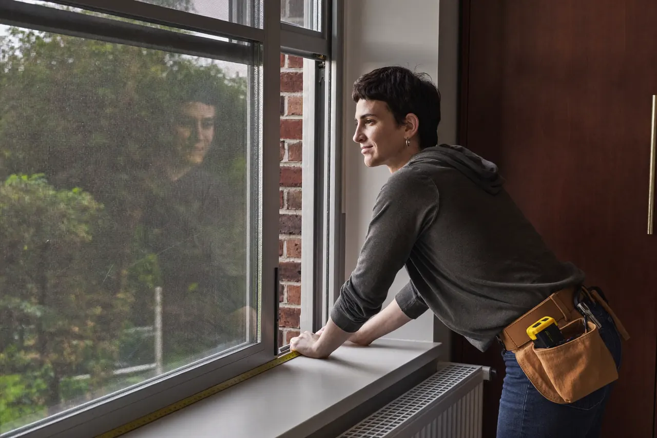 Installer measuring a window reveal for a quote